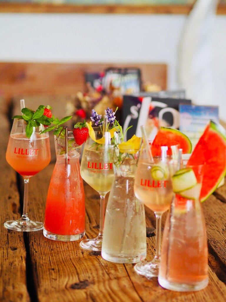 Bunte Cocktails mit Lillet auf einem Holztisch